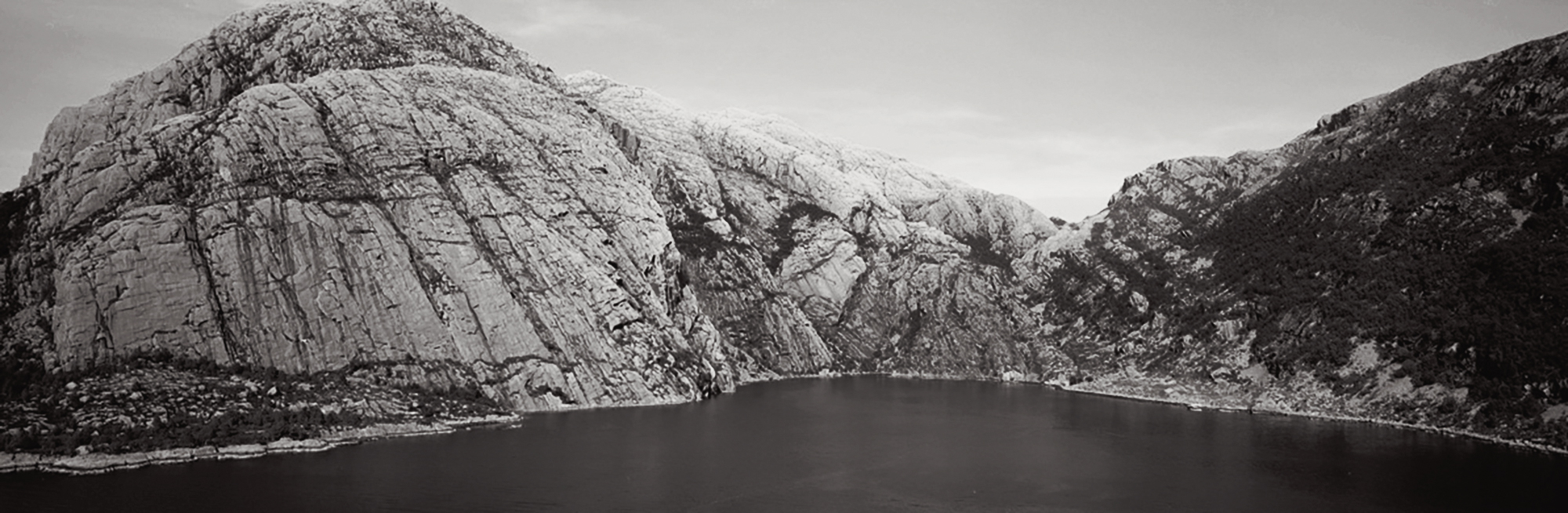 Panoramic picture from Vingen with Vingepollen opposite. The carvings are scattered around the area, on rocky outcrops, earthen blocks and smaller rocks. Originally, a waterfall tumbled down the mountainside deep in the pollen, but this has now been regulated away Vingen Rock Art Carvings Norway